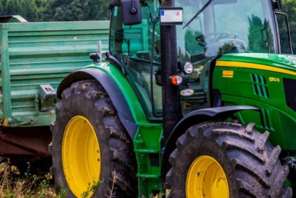trattore agricolo con carro parcheggiato in un campo fiorito