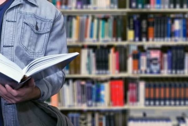uno studente sfoglia un libro in una biblioteca scolastica