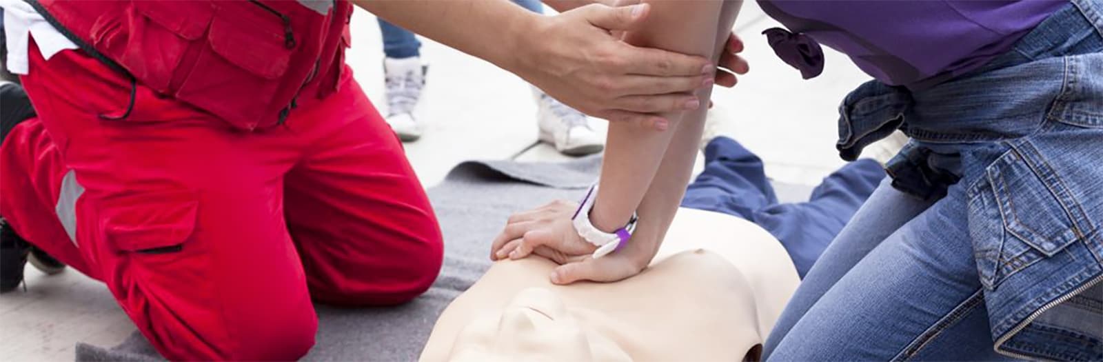 istruttore primo soccorso insegna massaggio cardiaco ad un corsista con un manichino