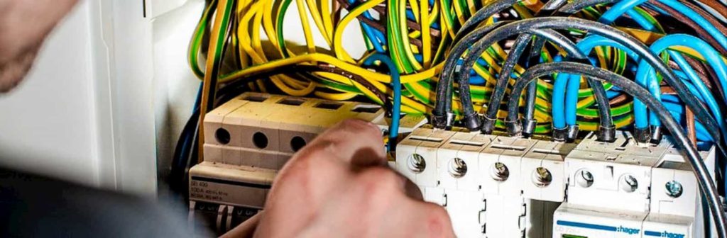 un elettricista sistema i fili elettrici di un contatore